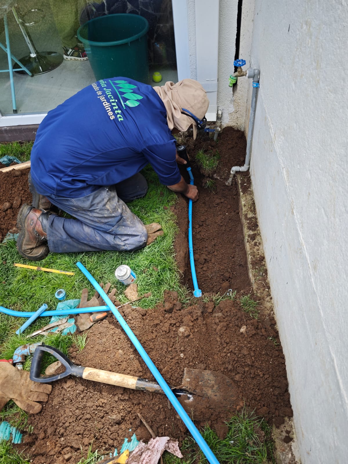 Instalador conectando tubería azul para aspersor emergente a llave de paso